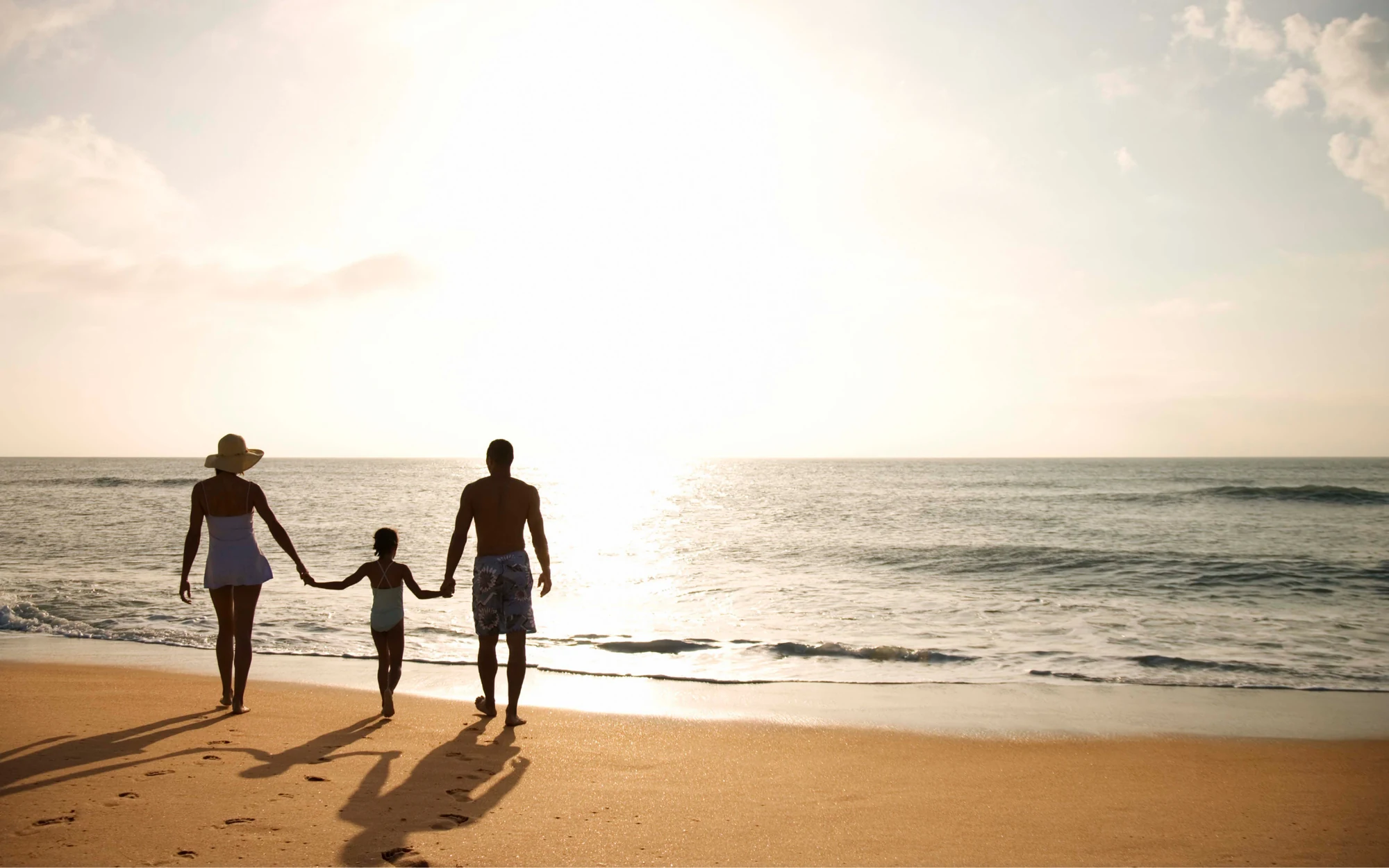 Family walking on Fort Lauderdale beach at sunset